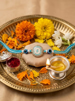 Thumbnail for NVR Blue Evil Eye & Artificial Stones Oval Shape Thread Rakhi with Roli Chawal Chandan - Dista