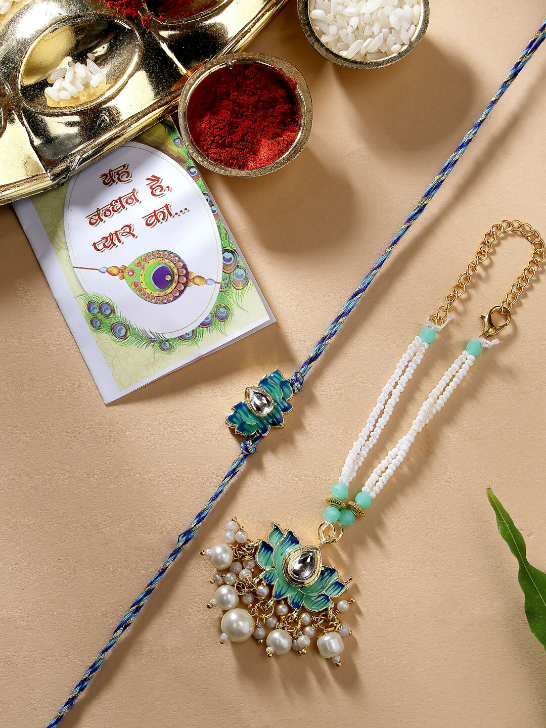 NVR Women & Men Set of 2 Turquoise Blue Lotus Shape Kundan-Studded & Beaded Rakhi Set With Roli Chawal & Chocolate - Distacart
