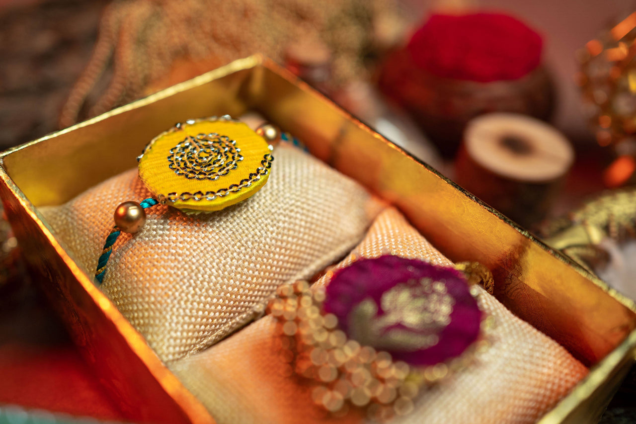 Nirmalaya Bhaiya Bhabhi Rakhi Set Yellow-Purple - Distacart